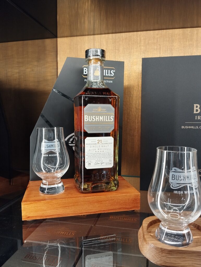 Image of Bushmills 21 year single malt whiskey bottle and glasses